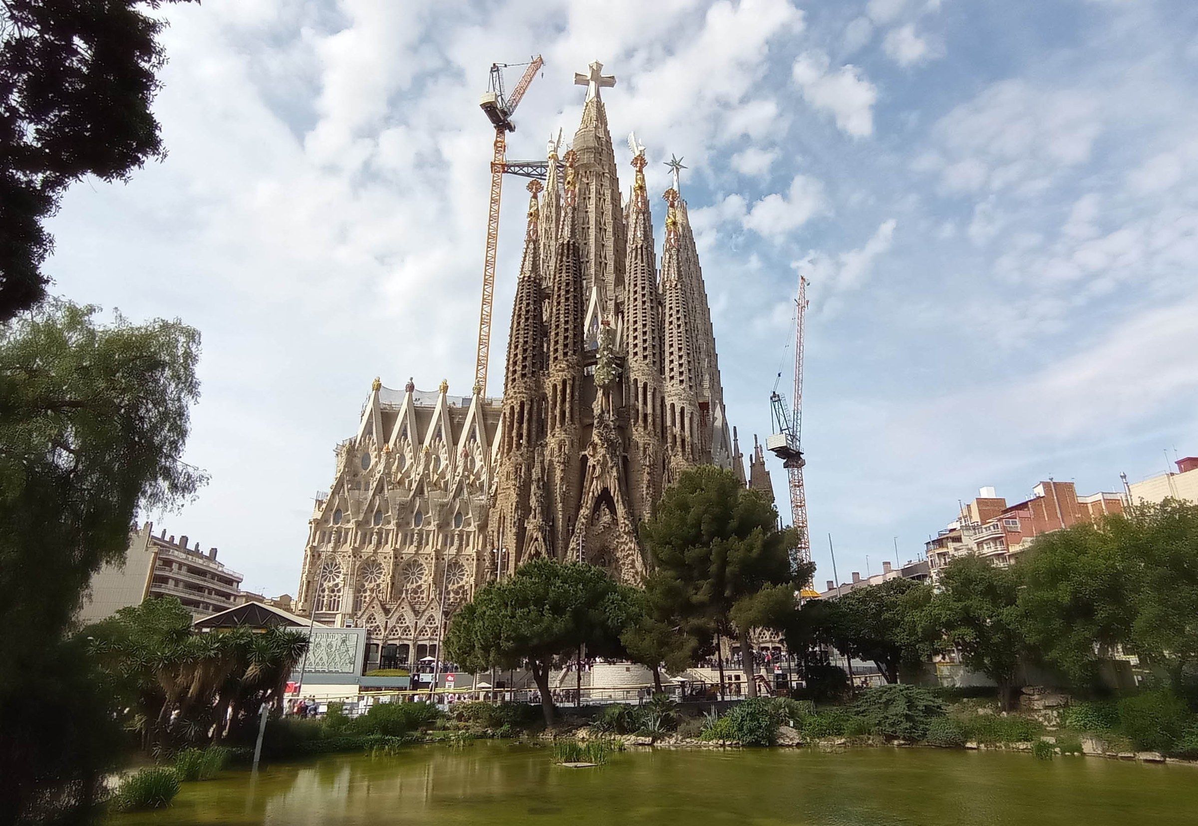 The Sagrada Família basilica in Barcelona seen from the pond at Plaça de Gaudí, its towers reflected in the water